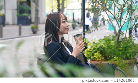 Female business person drinking coffee in the city Female business person drinking coffee in the city 114261005