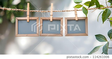 close up of a 3 blank note papers, photo frame on a rope with clothespins white background close up of a 3 blank note papers, photo frame on a rope with clothespins white background 114261006