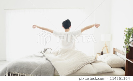 A man wakes up and stretches A man wakes up and stretches 114261364