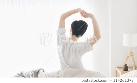 A man wakes up and stretches A man wakes up and stretches 114261372