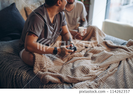 Perfect morning begins with lover and coffee in bed. Two guys resting in bed. 114262357