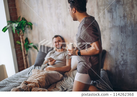 Perfect morning begins with lover and coffee in bed. Two guys resting in bed. Perfect morning begins with lover and coffee in bed. Two guys resting in bed. 114262368