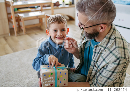 Dad get a handmade gift from little son, present wrapped in diy homemade wrapping paper. Happy Fathers day concept. 114262454
