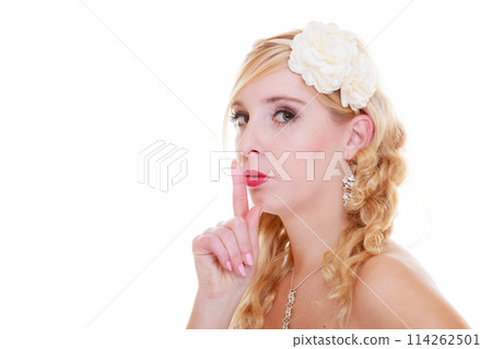 Bride in white wedding dress showing silence sign 114262501