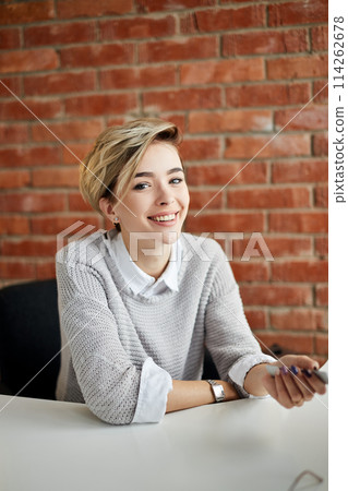 positive blond female secretary at the table 114262678