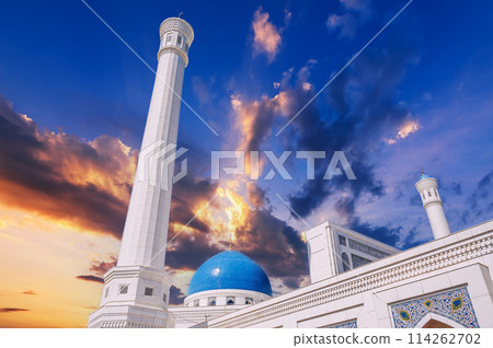 high white minaret and blue dome of modern Islamic Masjid Minor Mosque in Tashkent in Uzbekistan on background of sunset sky high white minaret and blue dome of modern Islamic Masjid Minor Mosque in Tashkent in Uzbekistan on background of sunset sky 114262702