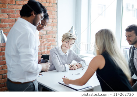 young fair-haired leader giving directions to new employees young fair-haired leader giving directions to new employees 114262720