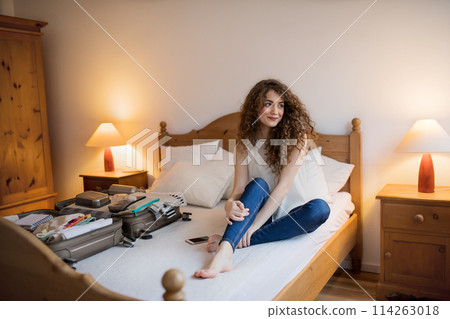 Beautiful woman planning summer vacation abroad, packing suitcase. Solo traveler preparing for trip. Beautiful woman planning summer vacation abroad, packing suitcase. Solo traveler preparing for trip. 114263018