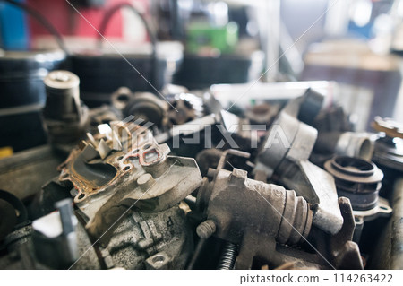 Metal components on workbench in auto repair shop. Mechanics repairing, maintaining car in garage, 114263422