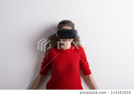 Young teenage girl with VR headset. Virutal reality, VR technology. Studio shot on white background with copy space. 114263838