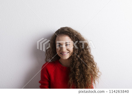 Portrait of a gorgeous teenage girl with curly hair. Studio shot, white background with copy space Portrait of a gorgeous teenage girl with curly hair. Studio shot, white background with copy space 114263840