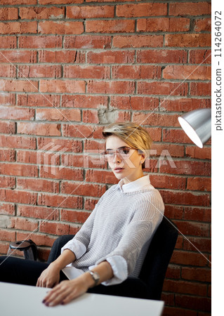 Trendy Fashion Woman sitting in the office with loft interior 114264072