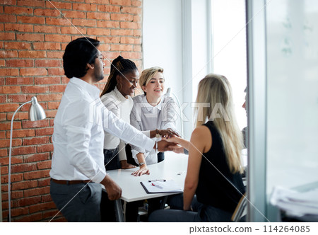 togetherness at work. cheerful office people putting joining their hands togetherness at work. cheerful office people putting joining their hands 114264085