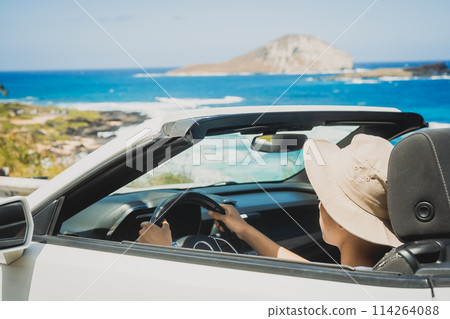 Young man driving an open car on a sunny day Young man driving an open car on a sunny day 114264088