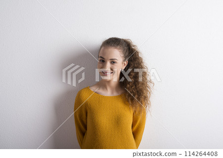 Portrait of a gorgeous teenage girl with curly hair. Studio shot, white background with copy space Portrait of a gorgeous teenage girl with curly hair. Studio shot, white background with copy space 114264408