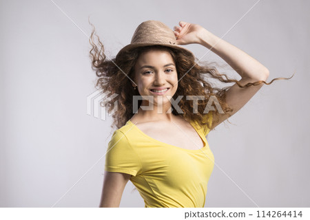 Portrait of a gorgeous teenage girl with curly hair and hat. Studio shot, white background with copy space Portrait of a gorgeous teenage girl with curly hair and hat. Studio shot, white background with copy space 114264414