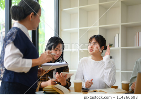 Pretty young woman student raising her hand to ask a question during class Pretty young woman student raising her hand to ask a question during class 114266698