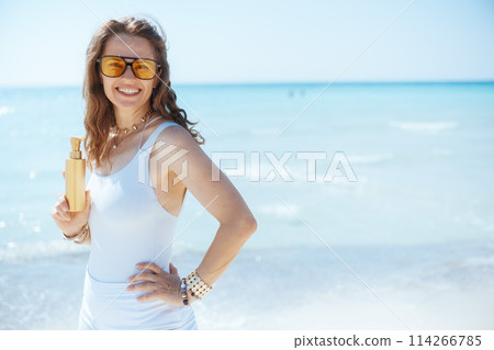 smiling modern woman on seashore with spf smiling modern woman on seashore with spf 114266785