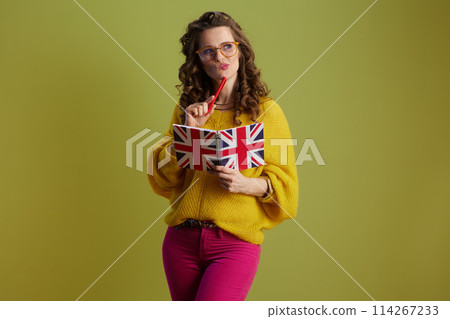 pensive fit woman in sweater and glasses isolated on green pensive fit woman in sweater and glasses isolated on green 114267233
