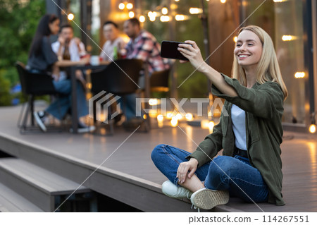 Woman making selfie with group of friends spending time making picnic 114267551