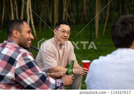 Cheerful friends enjoying cold beer at backyard party Cheerful friends enjoying cold beer at backyard party 114267617