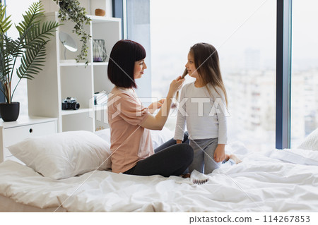 Happy Caucasian family having fun on bad on weekend morning. Happy Caucasian family having fun on bad on weekend morning. 114267853