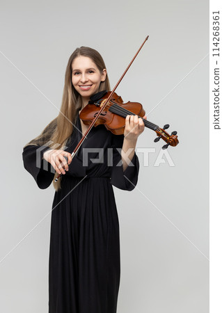 Elegant woman playing violin wearing black attire Elegant woman playing violin wearing black attire 114268361