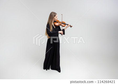 Beautiful young woman playing violin Beautiful young woman playing violin 114268421
