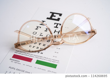 Glasses on eye testing exam chart to check eyesight accuracy of reading. 114268695