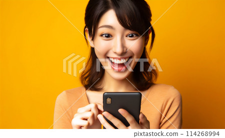 A woman who is surprised and happy when she sees her smartphone 114268994