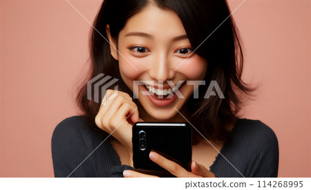一個女人看著她的智慧型手機時感到驚訝和高興 114268995