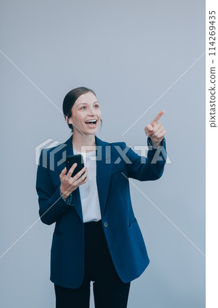 Portrait of a happy asian businesswoman using mobile phone isolated over white background 114269435