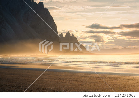 Sunrise shines with wave spray on Vestrahorn mountain during summer at Stokksnes peninsula, Iceland Sunrise shines with wave spray on Vestrahorn mountain during summer at Stokksnes peninsula, Iceland 114271063