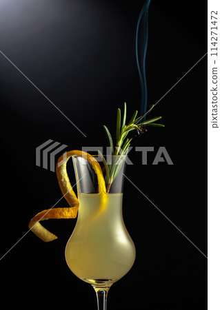Limoncello garnished with a steaming rosemary branch. 114271472