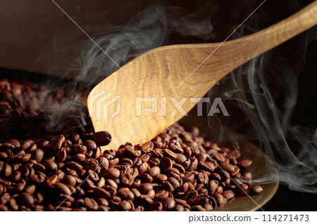 Coffee beans are smoky in a roasting pan. 114271473