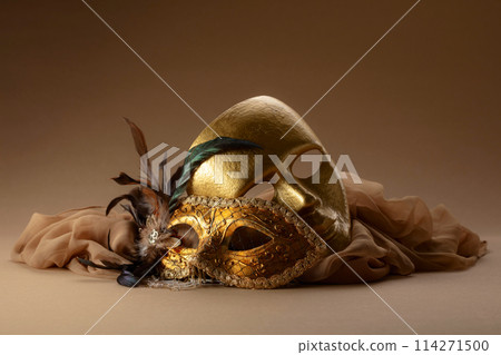 Golden Venetian carnival masks on a beige background. Golden Venetian carnival masks on a beige background. 114271500