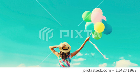Happy joyful woman with bunch of colorful balloons in summer straw hat on blue sky background Happy joyful woman with bunch of colorful balloons in summer straw hat on blue sky background 114271962