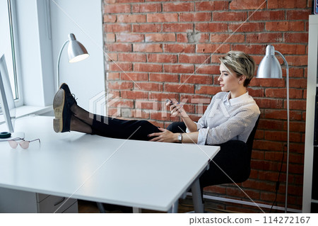 blond stylish leader watching TV at work blond stylish leader watching TV at work 114272167