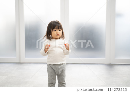 Girl tidying up toys 114272213