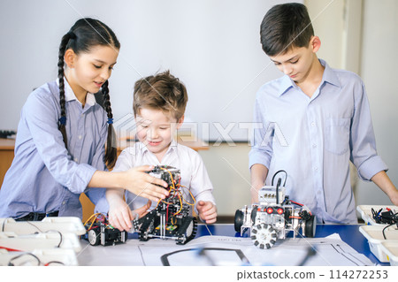 Kids playing with electrical robot while visiting robotics exhibition 114272253