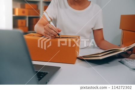 Startup small business entrepreneur SME, asian woman receive order on phone. Success young Asian small business owner home office, online sell marketing delivery, SME e-commerce telemarketing concept 114272302