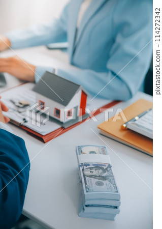 Real estate agent talked about the terms of the home purchase agreement and asked the customer to sign the documents to make the contract legally, Home sales and home insurance concept. Real estate agent talked about the terms of the home purchase agreement and asked the customer to sign the documents to make the contract legally, Home sales and home insurance concept. 114272342