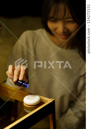 A woman is soothed by aroma before going to bed A woman is soothed by aroma before going to bed 114272531