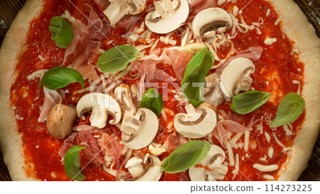 Super slow motion of falling various ingredients on pizza dough with sugo, top down view 114273225