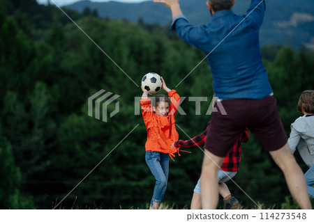 Young students playing with teacher outdoors, in nature, during field teaching class, running with ball. Dedicated teachers during outdoor active education. 114273548