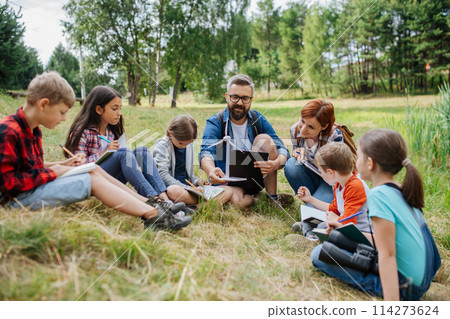 Students learning about renewable wind energy during field teaching class. Outdoor active education helping young student to learn about ecology and sustainability. 114273624