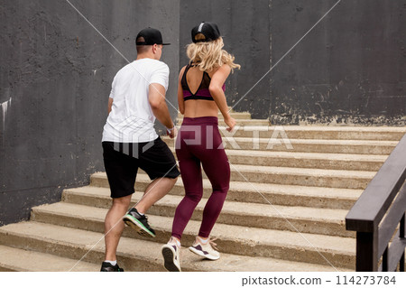 fitness, sport, people, exercising and lifestyle concept - couple running upstairs on city stairs 114273784