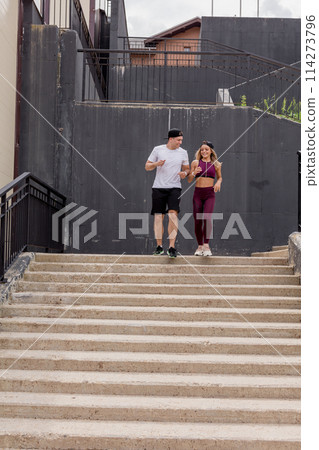 Couple running on stairs in morning, jogging in urban area with starecases. Couple running on stairs in morning, jogging in urban area with starecases. 114273796