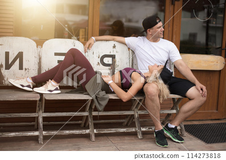 Man and woman dating in mountain outdoor cafe after sports workout Man and woman dating in mountain outdoor cafe after sports workout 114273818
