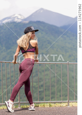 Athletic woman resting after a hard training in the mountains at sunset. Sport tight clothes. Athletic woman resting after a hard training in the mountains at sunset. Sport tight clothes. 114273962